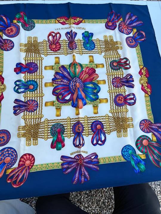 Carré de soie imprimé aux couleurs vives, déplié sur une table